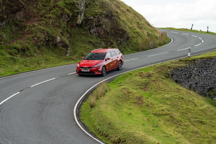 Red Kia Ceed Sportswagon driving on a winding road