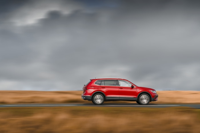 Red Volkswagen Tiguan Allspace Elegance driving on road