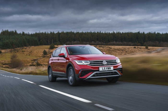 Red Volkswagen Tiguan Allspace Elegance driving on a road