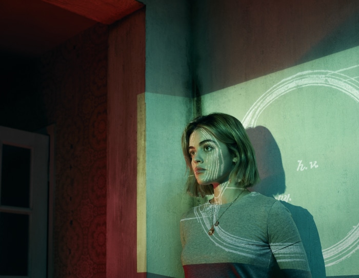 Lucy Hale in a room with projected patterns