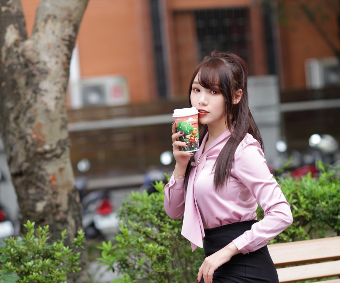 Asian woman with brunette hair drinking coffee