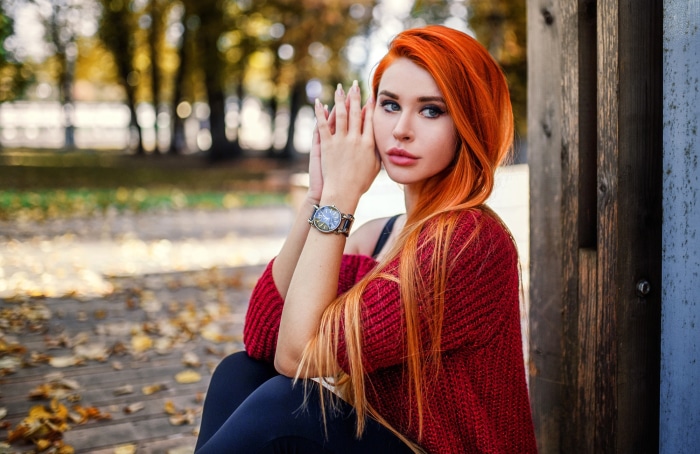 Woman with red hair sitting outdoors