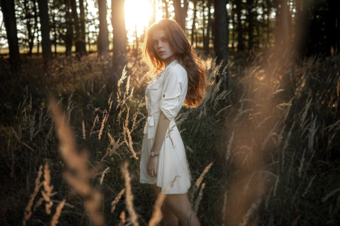 Brunette model in a white dress in a forest