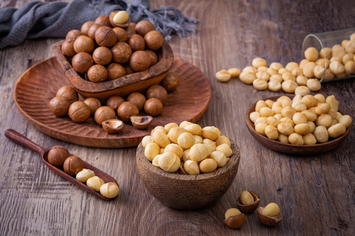 Macadamia nuts in bowls and on a wooden scoop