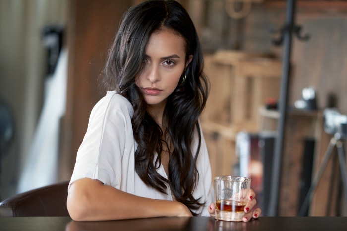 Woman with black hair holding a drink