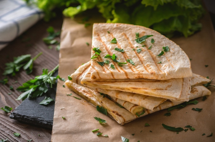Stack of grilled quesadillas with parsley garnish