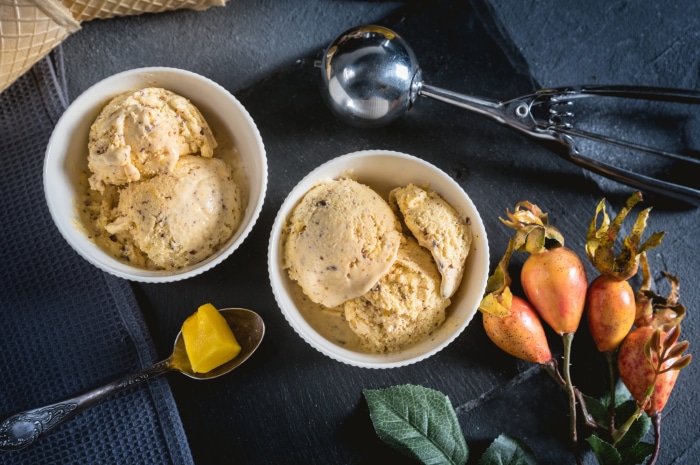 Still life of ice cream in bowls with rose hips