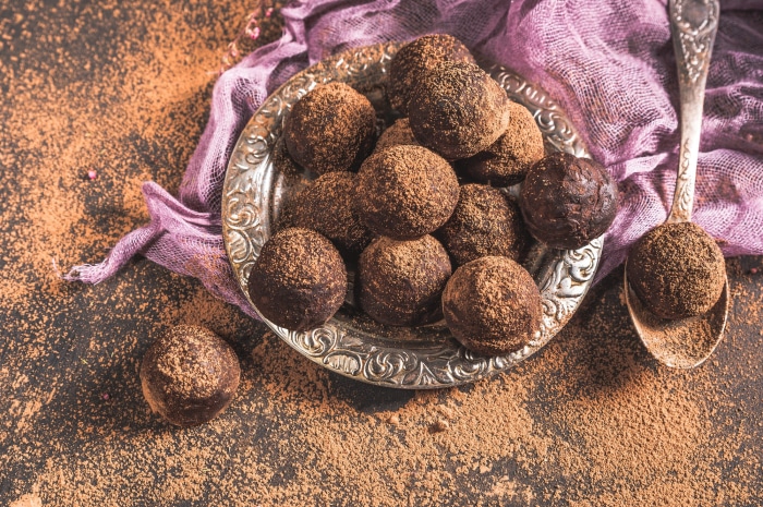 Chocolate truffles dusted with cocoa powder on a silver plate