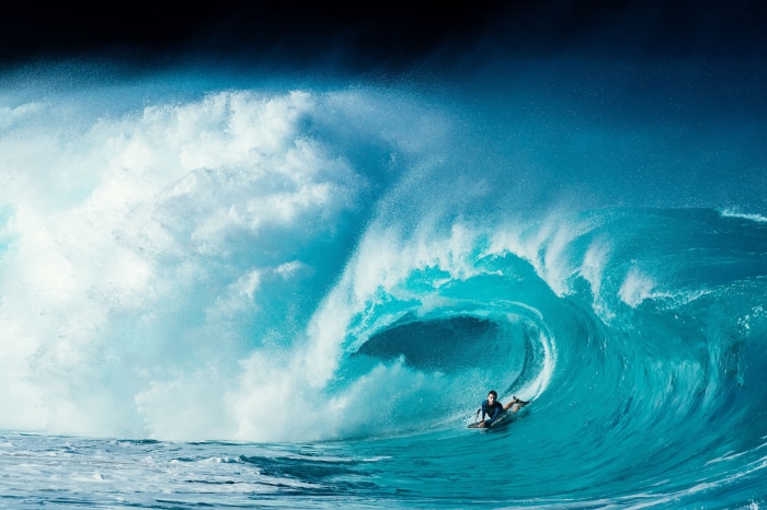 Surfer riding a massive wave in 4K
