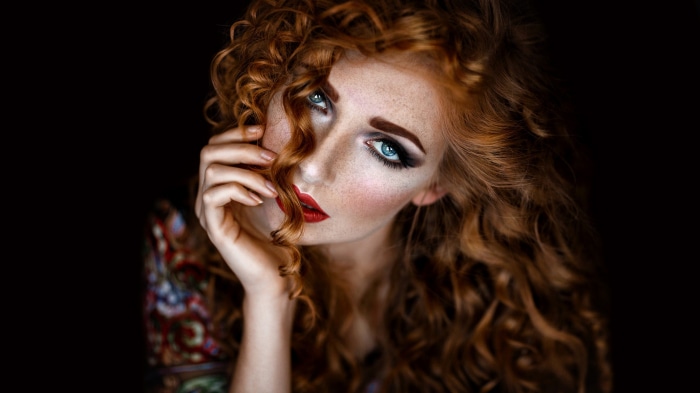 Redhead woman with blue eyes and curly hair