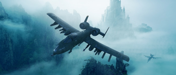 A-10 Thunderbolt II aircraft flying over misty mountains