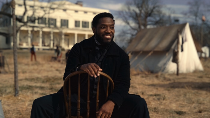 Man in Black Coat Sitting Outdoors
