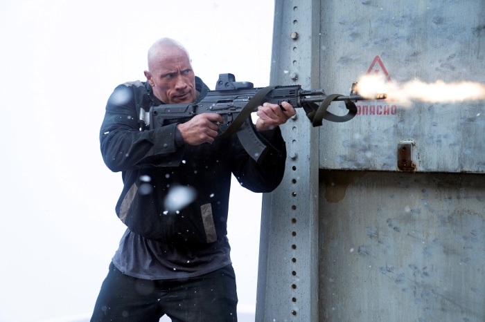 Dwayne Johnson firing a rifle