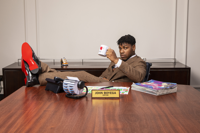John Boyega sitting at a desk