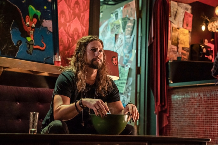 Man with long hair holding a bowl