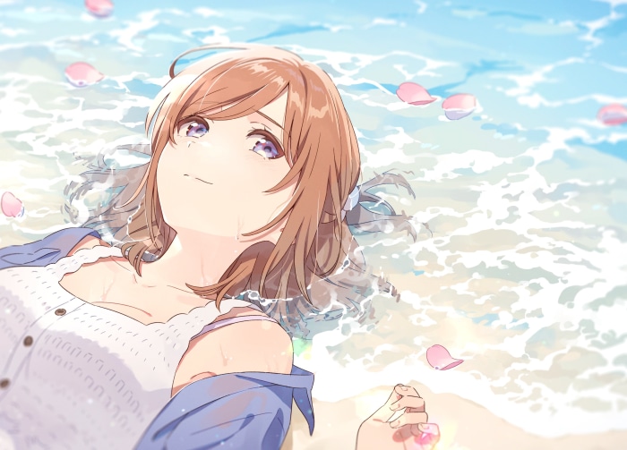Girl lying in the ocean with petals