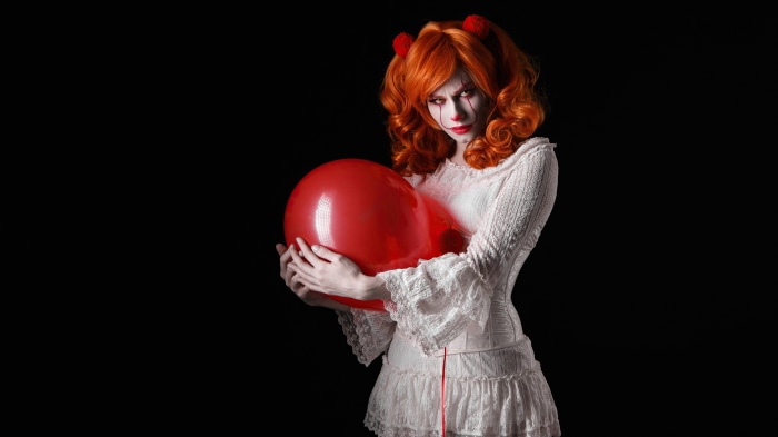 Pennywise the Dancing Clown from It holding a red balloon
