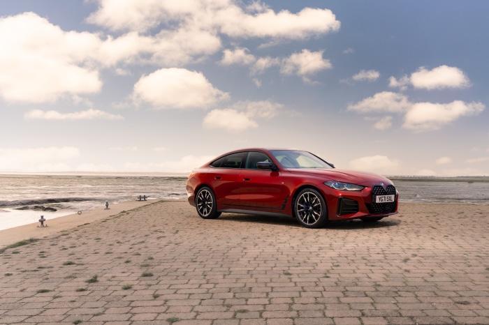 Red BMW M440i xDrive Gran Coupé by the sea