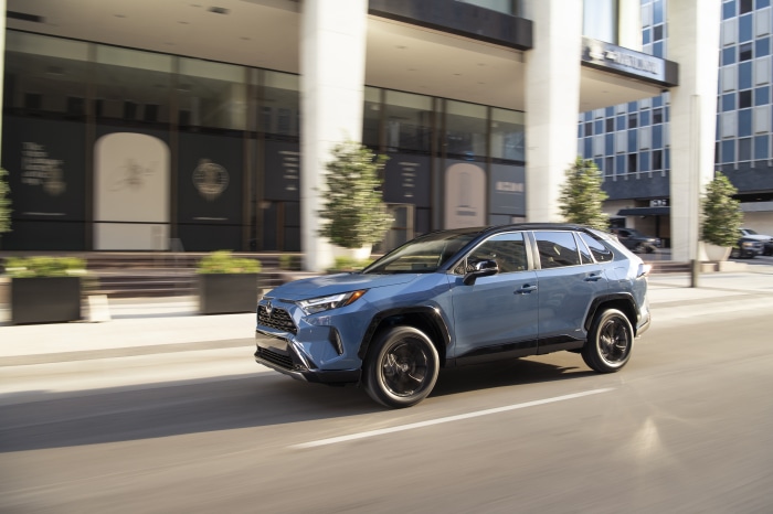 Blue Toyota RAV4 XSE Hybrid driving on city street