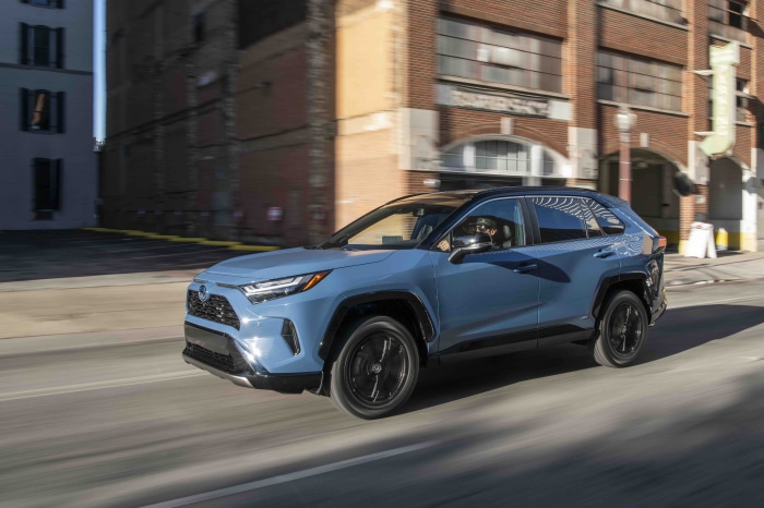 Blue Toyota RAV4 XSE Hybrid driving on city street
