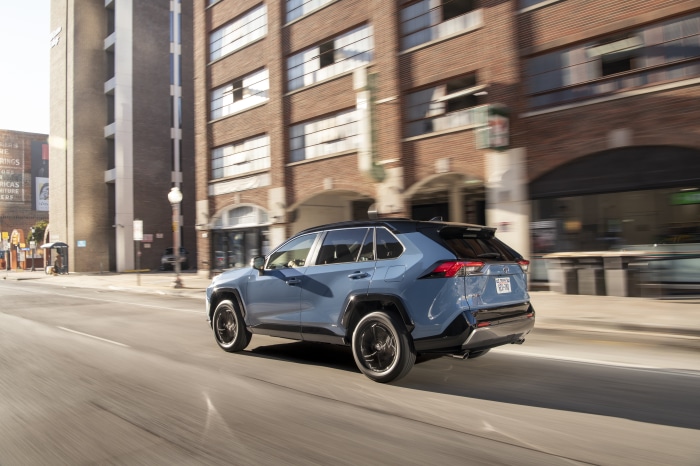 Blue Toyota RAV4 XSE Hybrid driving on city street