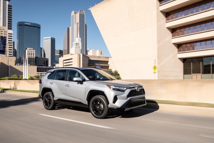 Silver Toyota RAV4 SE Hybrid driving in city