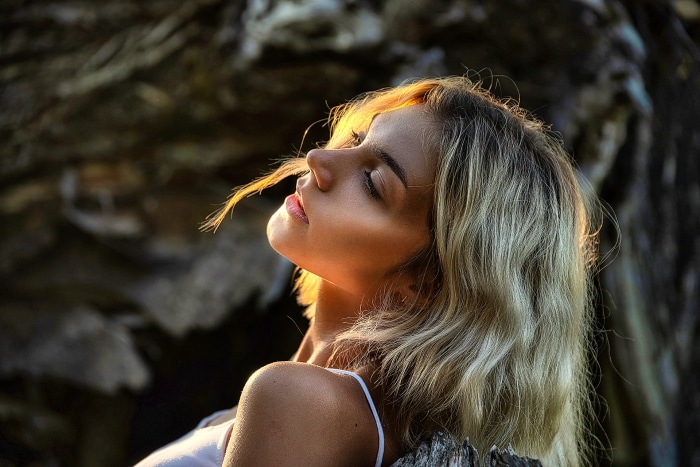 Woman with eyes closed in sunlight