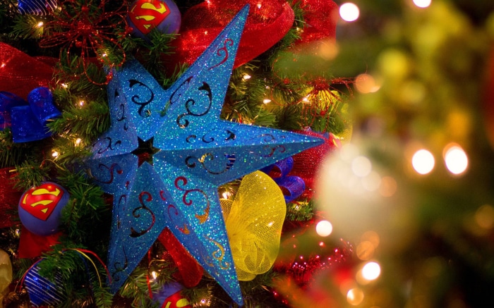 Blue star ornament on a Christmas tree with Superman ornaments