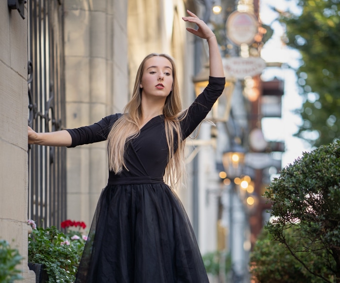 Ballerina in black dress posing outdoors