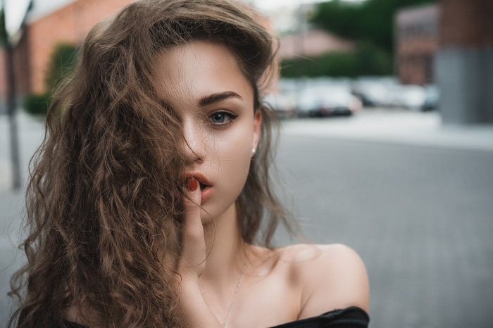 Brunette woman with curly hair in black top