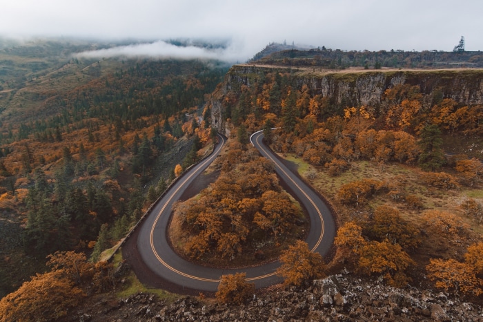 Winding road through autumn forest on a cliff