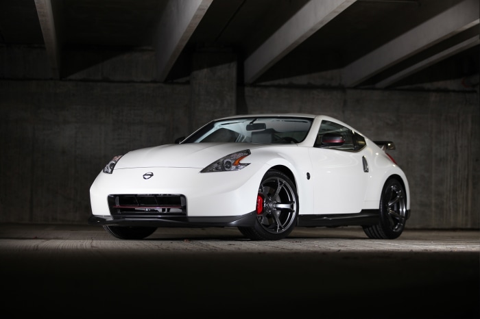 White Nissan 370Z Nismo parked under a concrete structure