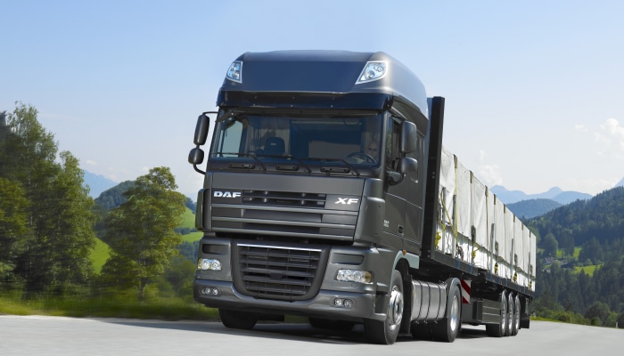 Dark gray DAF XF semi-truck driving on a road