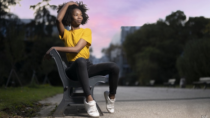Model sitting on a park bench at dusk