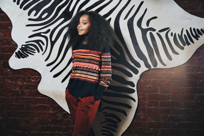 Young girl with black hair in colorful sweater