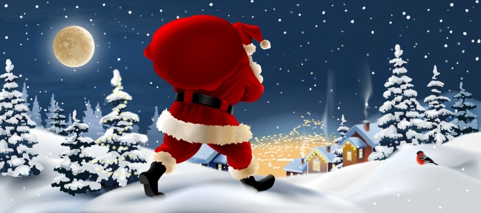 Santa Claus carrying a sack in a snowy village at night