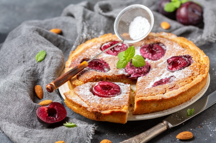 Plum cake with powdered sugar and mint