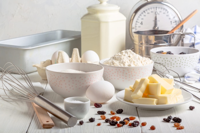 Baking ingredients with butter, flour, eggs, and raisins