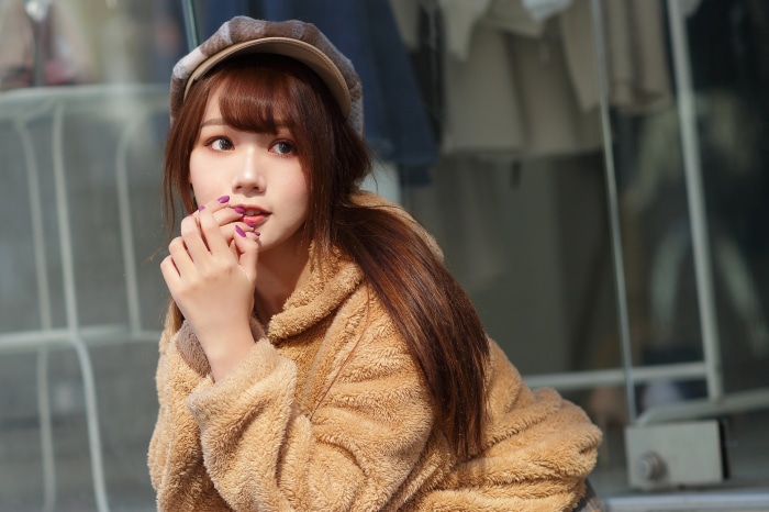 Asian woman with brown hair wearing a fuzzy jacket and hat