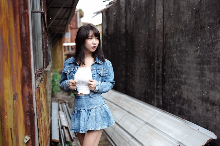 Asian woman with black hair wearing denim skirt and jacket