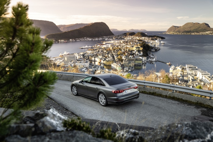Audi A8 sedan on a scenic road overlooking a coastal town