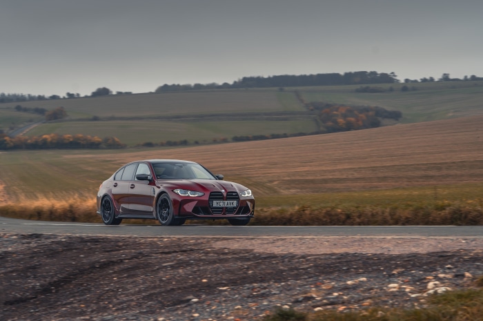 Red BMW M3 Competition M xDrive on a road