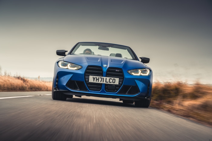 Blue BMW M4 Competition Convertible driving on road