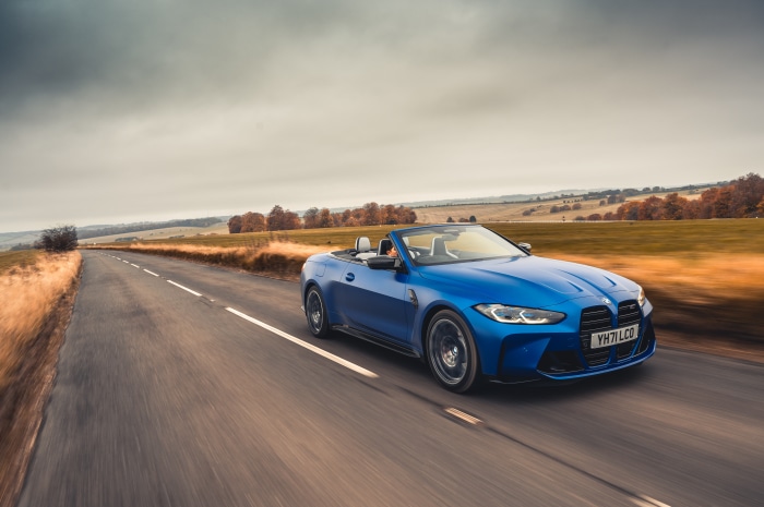 Blue BMW M4 Competition Cabriolet driving on a road