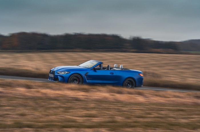 Blue BMW M4 Competition M xDrive Cabriolet driving