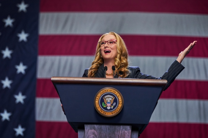 Meryl Streep at a podium with US flag