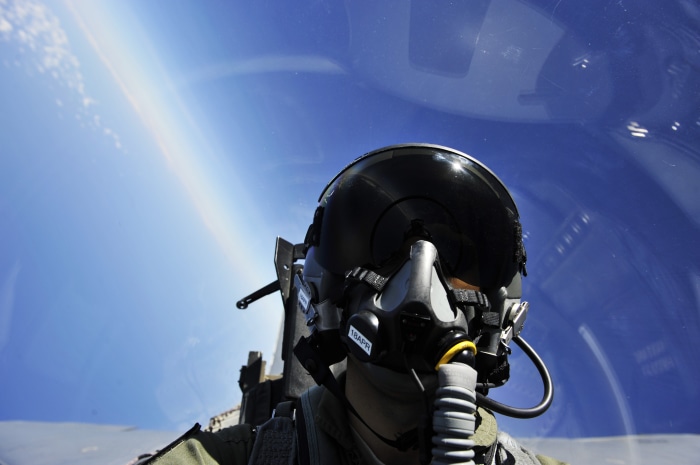 Fighter pilot in cockpit documenting operations