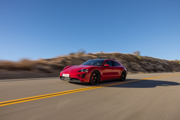 Red Porsche Taycan GTS Sport Turismo driving on road