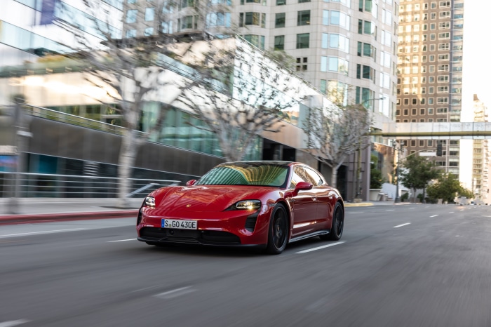 Red Porsche Taycan GTS Sport Turismo driving on city street