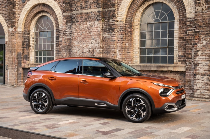 Orange Citroen C4 SUV parked in front of brick building